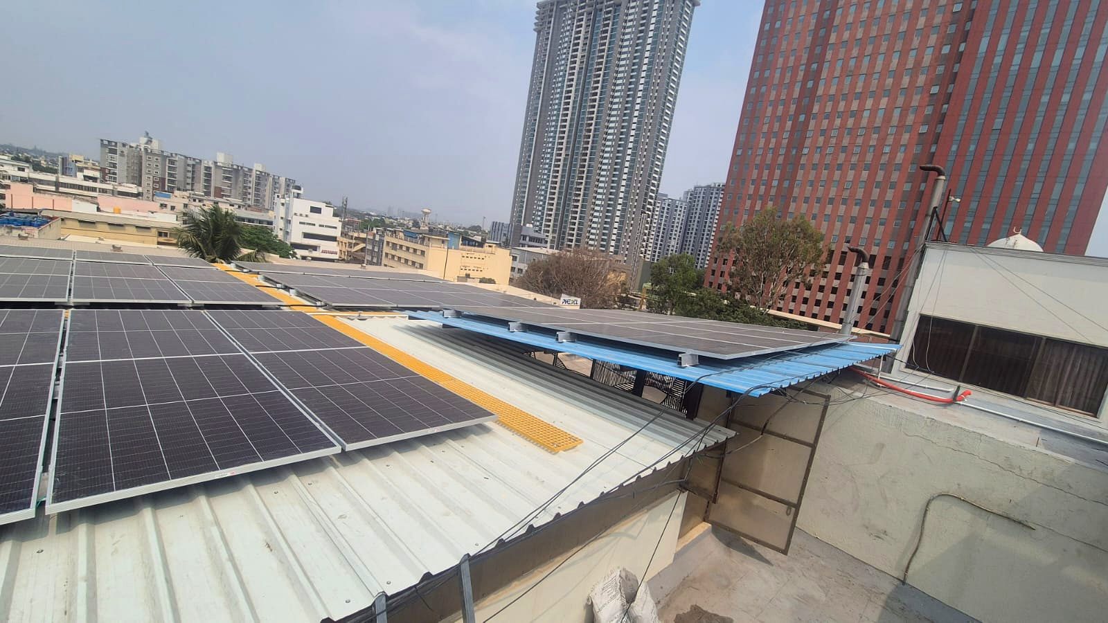 Multi-level rooftop solar arrays against the Bangalore skyline