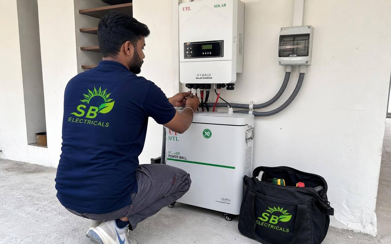 SB Electricals technician wiring a hybrid solar inverter and battery with a branded tool bag